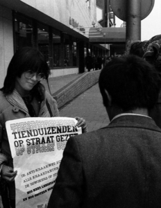 835031 Afbeelding van een sympathisante van de kraakbeweging die, bij het gekraakte voormalige winkelpand van Miss Etam ...